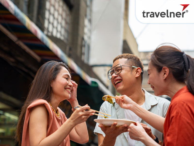 Group of tourists enjoys eating traditional street food in Bangkok, Thailand Group of tourists enjoys eating traditional street food in Bangkok, Thailand